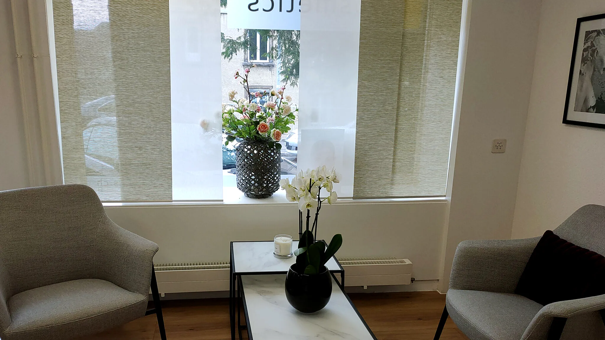 Empfangsbereich mit Sesseln, Orchidee und grossen Fenstern